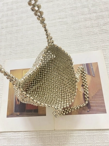 Sac à main géométrique argenté avec bandoulière assortie sur tissu tissé blanc épuré