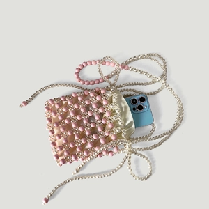 Détail du sac de téléphone fait main en perles montrant l'espace pour un smartphone bleu