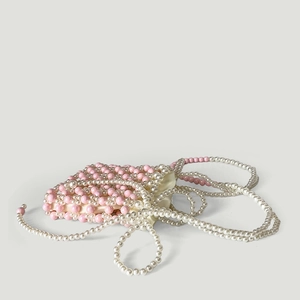 Détail du sac à main en perles roses et crème avec doublure satinée et longue bandoulière