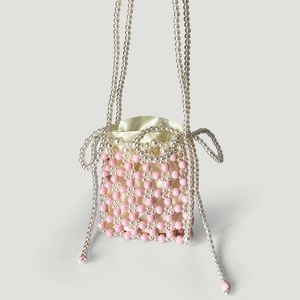 Gros plan du sac seau perlé rose et blanc fait main avec cordon en satin