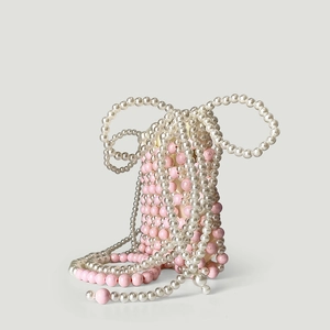 Détail macro de perles roses et blanches tissées main sur un sac à main vintage