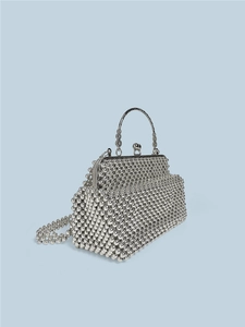Chic silver beaded handbag with ornate metal handle and crossbody strap, 45-degree angle view