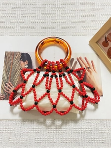 Detailed shot of retro beaded handbag with red and black mesh and amber resin handle
