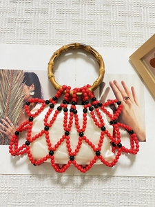 Detail of handmade beaded grid and natural bamboo circular handle on woven handbag