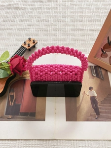 Pink handmade beaded mini bag with acrylic beads and phone for scale reference