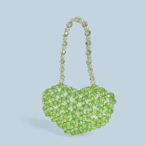 Vue détaillée du sac en perles vertes en forme de cœur avec anse style perle