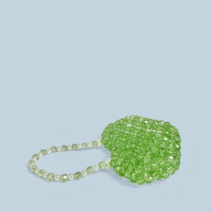 Vue détaillée d'un sac à main artisanal en perles vertes en forme de cœur sur bleu