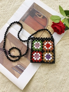 Handmade black beaded mini crossbody bag with colorful floral patterns and pearl strap