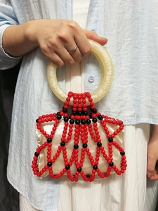 Handmade beaded handbag with red and black resin beads and round marble-style handles