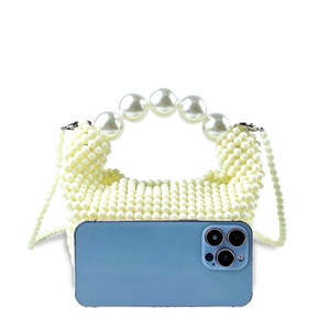 Detail of handmade pearl beaded handbag with large top handle and smartphone for size scale