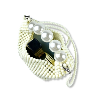 Detail view of mini pearl beaded handbag showing interior space for lipstick and makeup