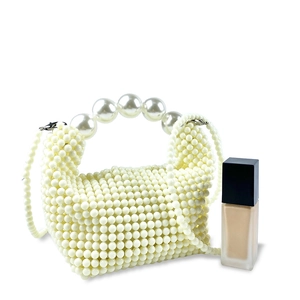 Close-up of handmade cream pearl woven handbag with large pearl handle and crossbody strap