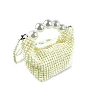 Detailed macro of a handmade white faux pearl woven handbag with top handle and strap