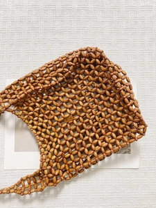 Close-up of vintage handmade woven tote with dark brown amber texture wooden beads
