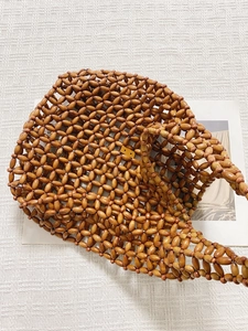 Detailed view of handmade vintage tote bag woven with deep brown oval wooden beads