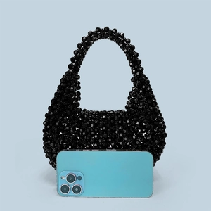 Detail of black handmade beaded handbag with smartphone for size reference scale