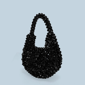 Close-up of handmade black beaded handbag with polished acrylic beads and woven texture