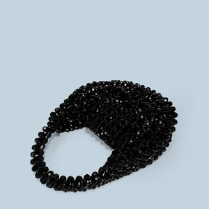 Close-up of handmade black faceted acrylic beads on a semi-circular luxury handbag