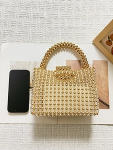 Vue de dessus d'un sac à main perlé à côté d'un smartphone montrant la taille et les perles