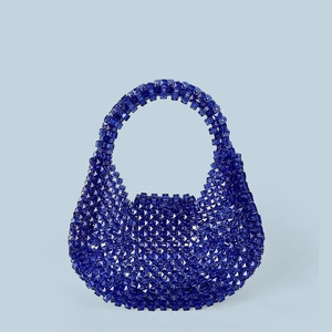 Detailed view of dark blue acrylic beads and handmade woven texture on a fashion handbag