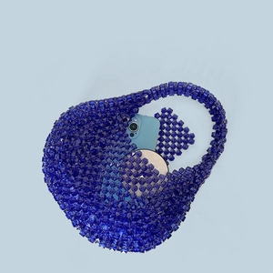 Detail of dark blue acrylic beaded handbag showing storage for phone and mirror