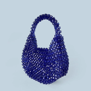 Detailed close-up of dark blue acrylic beaded handbag with faceted texture and glossy finish