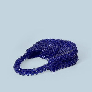 Macro shot of dark blue acrylic beads showing geometric texture on a handmade handbag