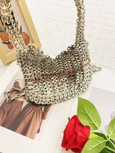 Silver metallic woven hobo bag with circular chain links and integrated handle