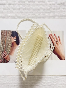 Sac bandoulière en perles blanches de style français exposé sur un magazine de mode