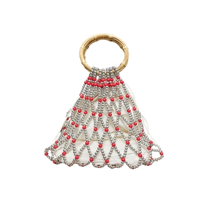 Detail of beaded mesh handbag with bamboo handles and white drawstring liner