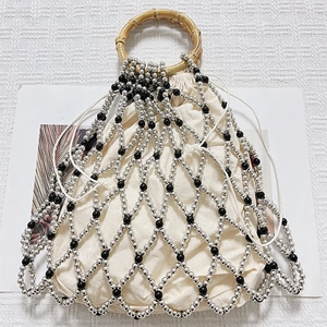 Top view of pearl beaded bag featuring bamboo handles and a linen drawstring inner pouch