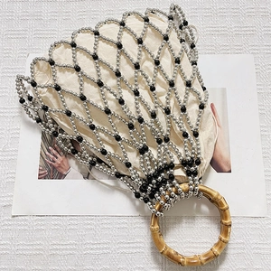 Detail of woven faux pearl mesh bag with bamboo handles and a canvas drawstring liner