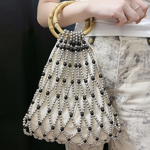 Detail of beaded tote bag with bamboo handles and white fabric inner lining