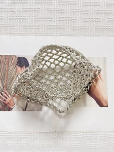 Handcrafted silver metallic beaded mesh handbag on a minimalist fashion magazine
