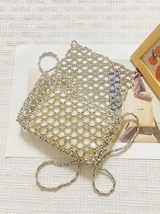 Sac à main artisanal en perles argentées avec design géométrique ajouré sur textile