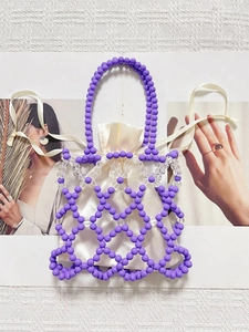 Detail of purple beaded woven handbag with white satin drawstring liner on a white backdrop