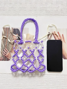 Top view of a purple beaded mini tote bag with a cream satin drawstring pouch and smartphone