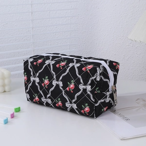 Detail of floral pencil case showing red rose patterns and durable metal zipper closure
