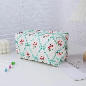 Detail view of quilted floral pencil case with red roses and green ribbon prints