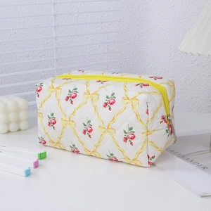 Detail of quilted floral pencil case with yellow ribbons and red rose patterns