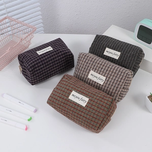 Plaid canvas cosmetic pouches in four colorful patterns with a minimalist top zipper design