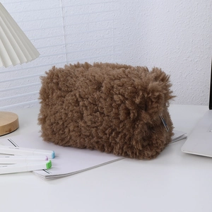 Macro view of plush brown lamb wool texture and metal zipper closure on pencil case