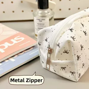 Detail of the high-quality metal zipper and canvas texture on a bow-patterned pencil case