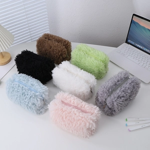 Detailed view of plush stationery bags in seven colors on a white office desk setup