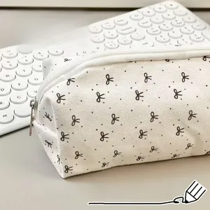 Detailed shot of fabric pouch with black polka dots and bows near laptop keyboard