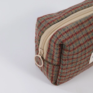 Detail of red and green plaid cosmetic bag with durable metal ring zipper and wool fabric