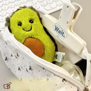 Floral makeup bag holding a cute plush avocado toy on a desk with a white keyboard