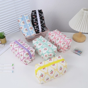 Quilted floral pencil cases with ribbon patterns in five pastel colors and zipper details