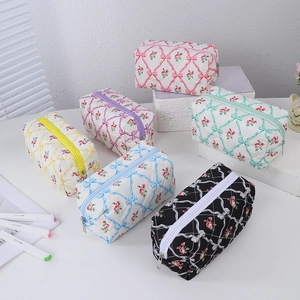 Detailed view of six colors of quilted floral pencil cases with ribbon patterns
