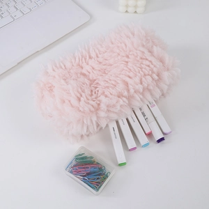 Close-up of soft pink faux fur pencil case with zipper closure on a white desk workspace